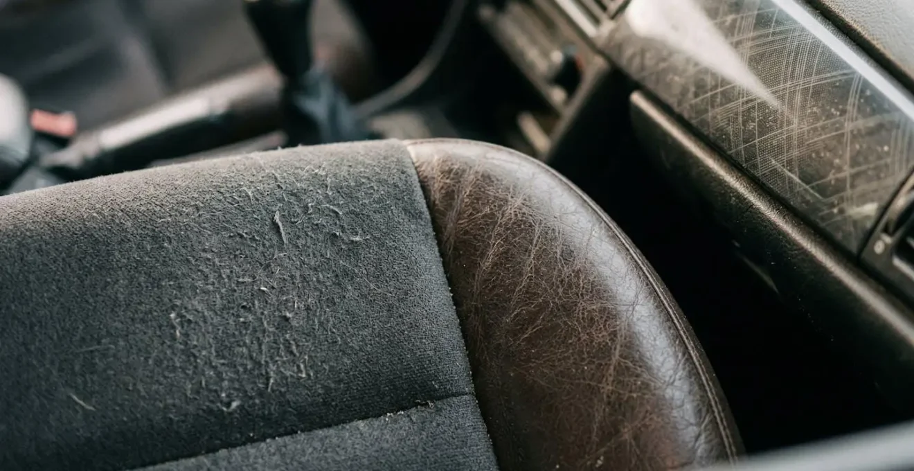 Close-up van versleten autostoel en dashboard materialen met zichtbare gebruikssporen