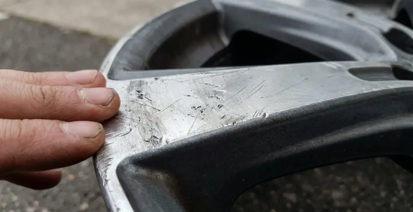Close-up inspectie van autovelg met focus op krassen en beschadigingen